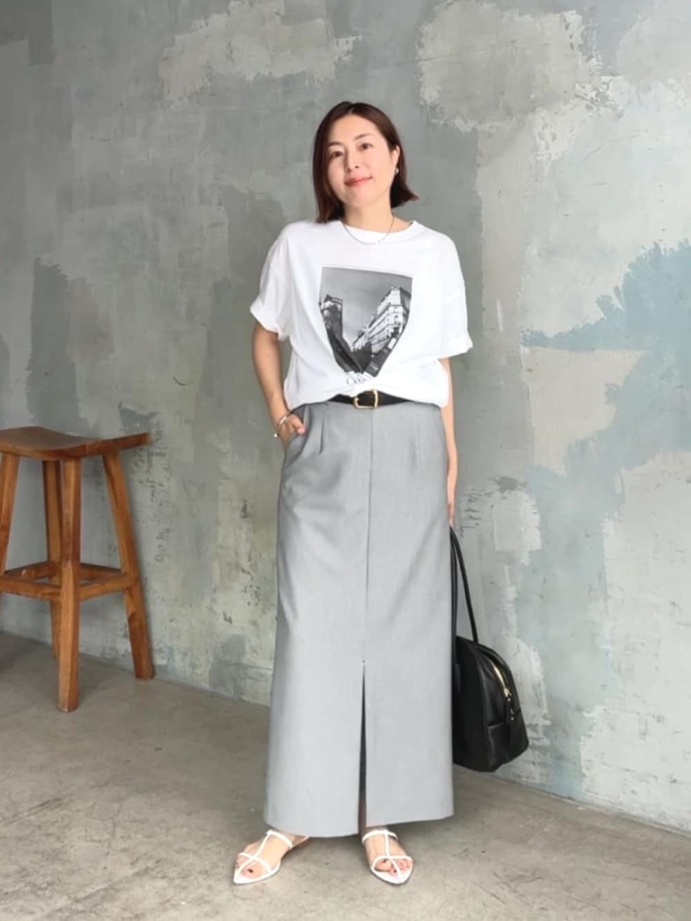 ホワイト系のTシャツ/カットソー、ホワイト系のサンダル、ブラック系のスカートを着用したレディースの夏コーディネートの5枚目の写真