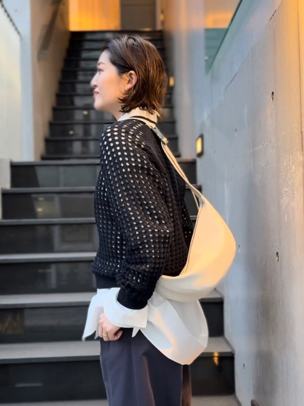 ブルー系のニット/セーター、ホワイト系のシャツ/ブラウス、ブルー系のチノパンツを着用したレディースの冬コーディネートの3枚目の写真