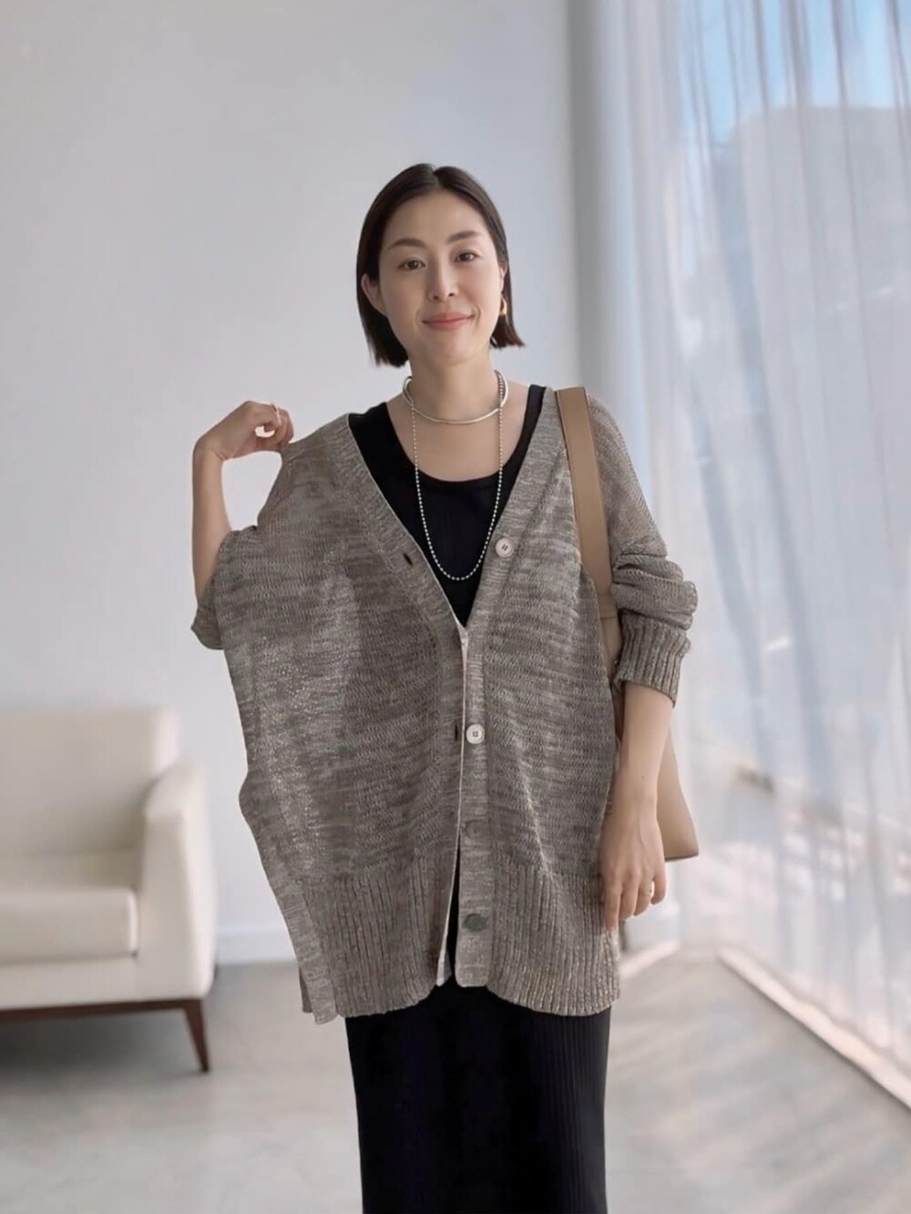 ブラウン系のカーディガン/ボレロ、ブラック系のワンピース、ブラック系のサンダルを着用したレディースの夏コーディネートの4枚目の写真