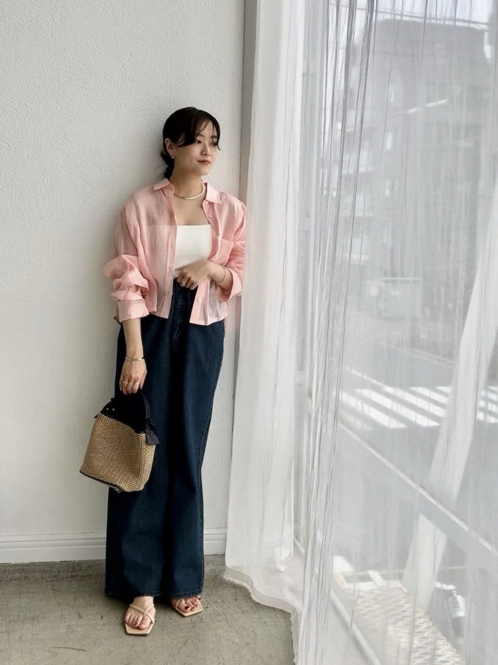 ピンク系のシャツ/ブラウス、ホワイト系のキャミソール、ブルー系のデニムパンツを着用したレディースの春コーディネートの3枚目の写真