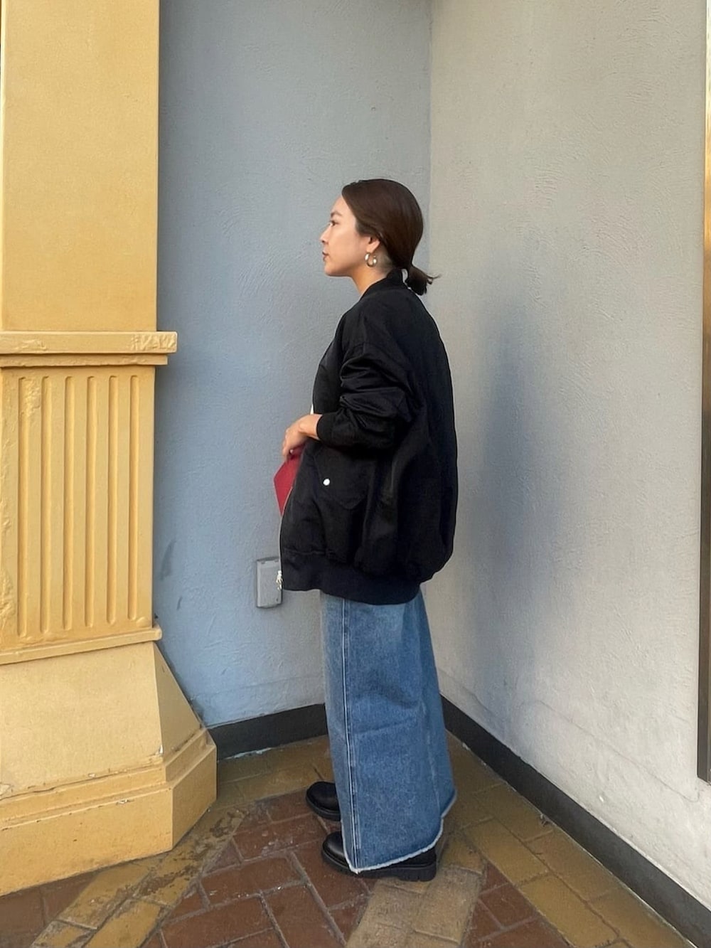 ホワイト系のニット/セーター、ブルー系のデニムスカート、ブラック系のブーツを着用したレディースの秋コーディネートの3枚目の写真