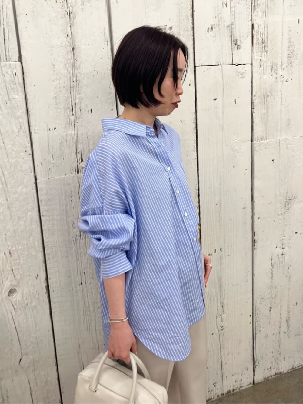 ホワイト系のボストンバッグ、ブルー系のシャツ/ブラウス、グリーン系のその他アウターを着用したレディースの春コーディネートの8枚目の写真