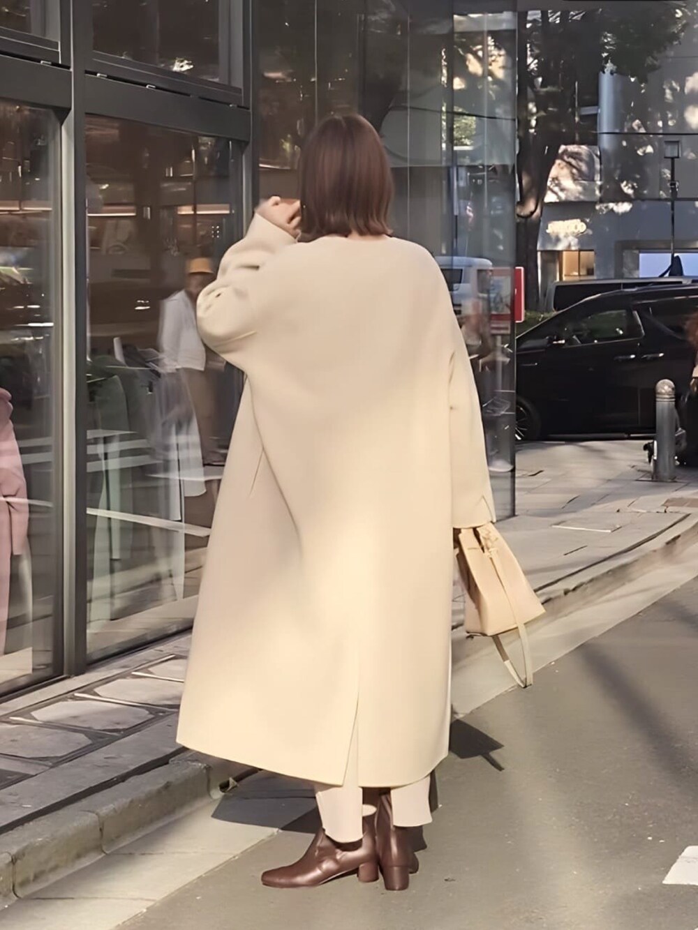 ベージュ系のスカート、ブラック系のブーツ、ベージュ系のニット/セーターを着用したレディースの秋コーディネートの3枚目の写真