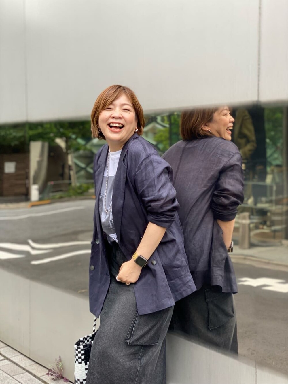 ブルー系のテーラードジャケット、ブルー系のデニムスカート、シルバー系のサンダルを着用したレディースの夏コーディネートの3枚目の写真