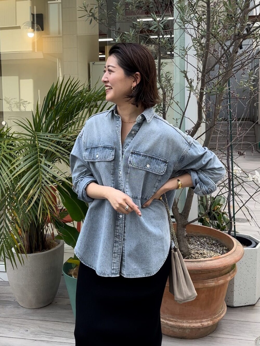 ブルー系のシャツ/ブラウス、ブラック系のスカート、ベージュ系のショルダーバッグを着用したレディースの冬コーディネートの4枚目の写真