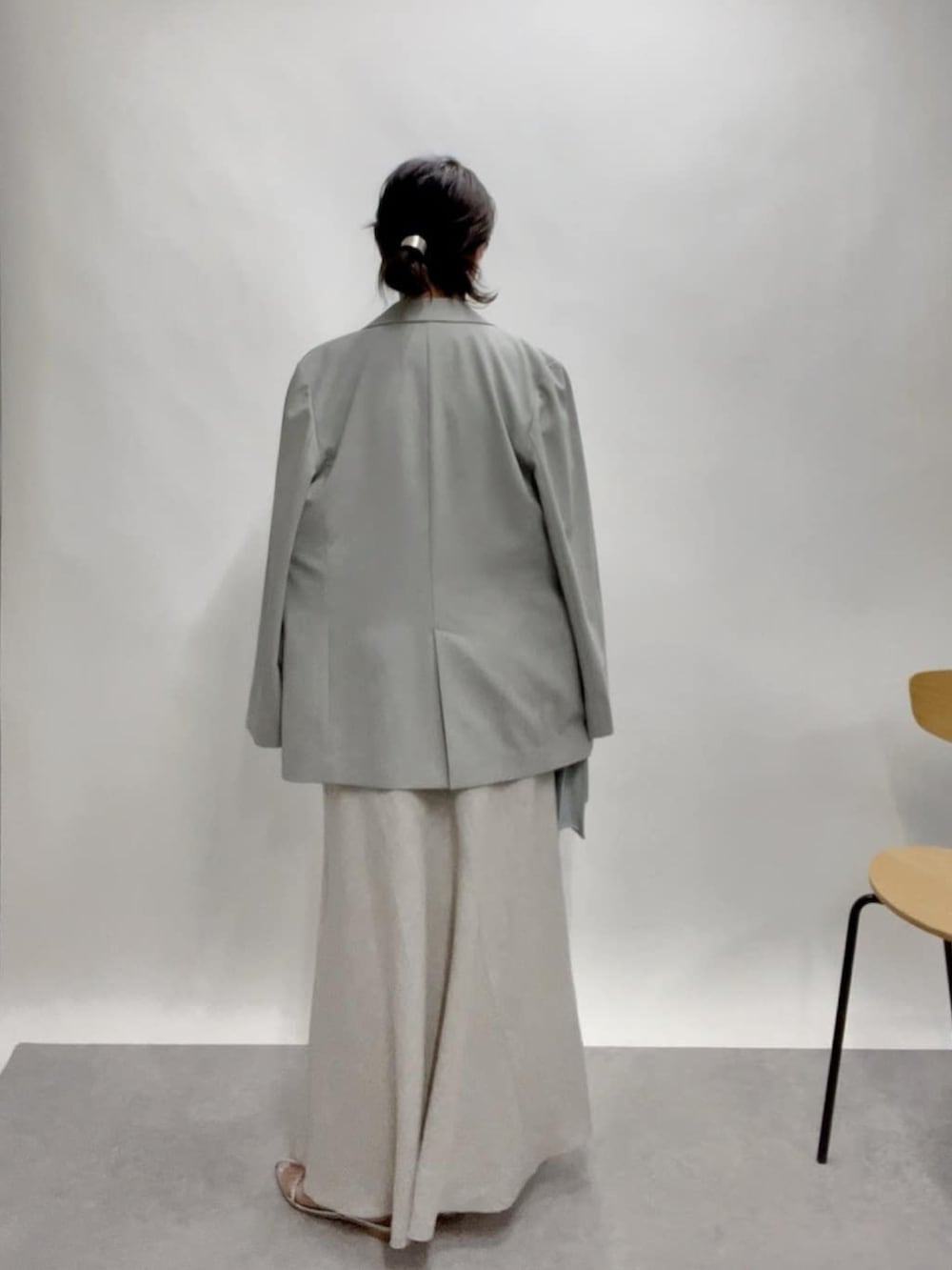 ベージュ系のテーラードジャケット、グリーン系のスカート、ブルー系のショルダーバッグを着用したレディースの春コーディネートの4枚目の写真