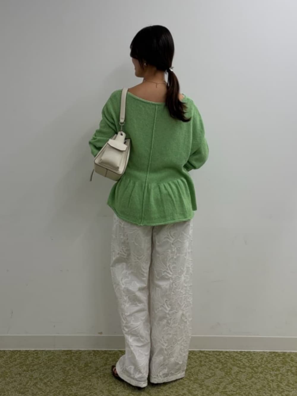 ホワイト系のショルダーバッグ、ブラウン系のサンダル、グリーン系のニット/セーターを着用したレディースの春コーディネートの4枚目の写真
