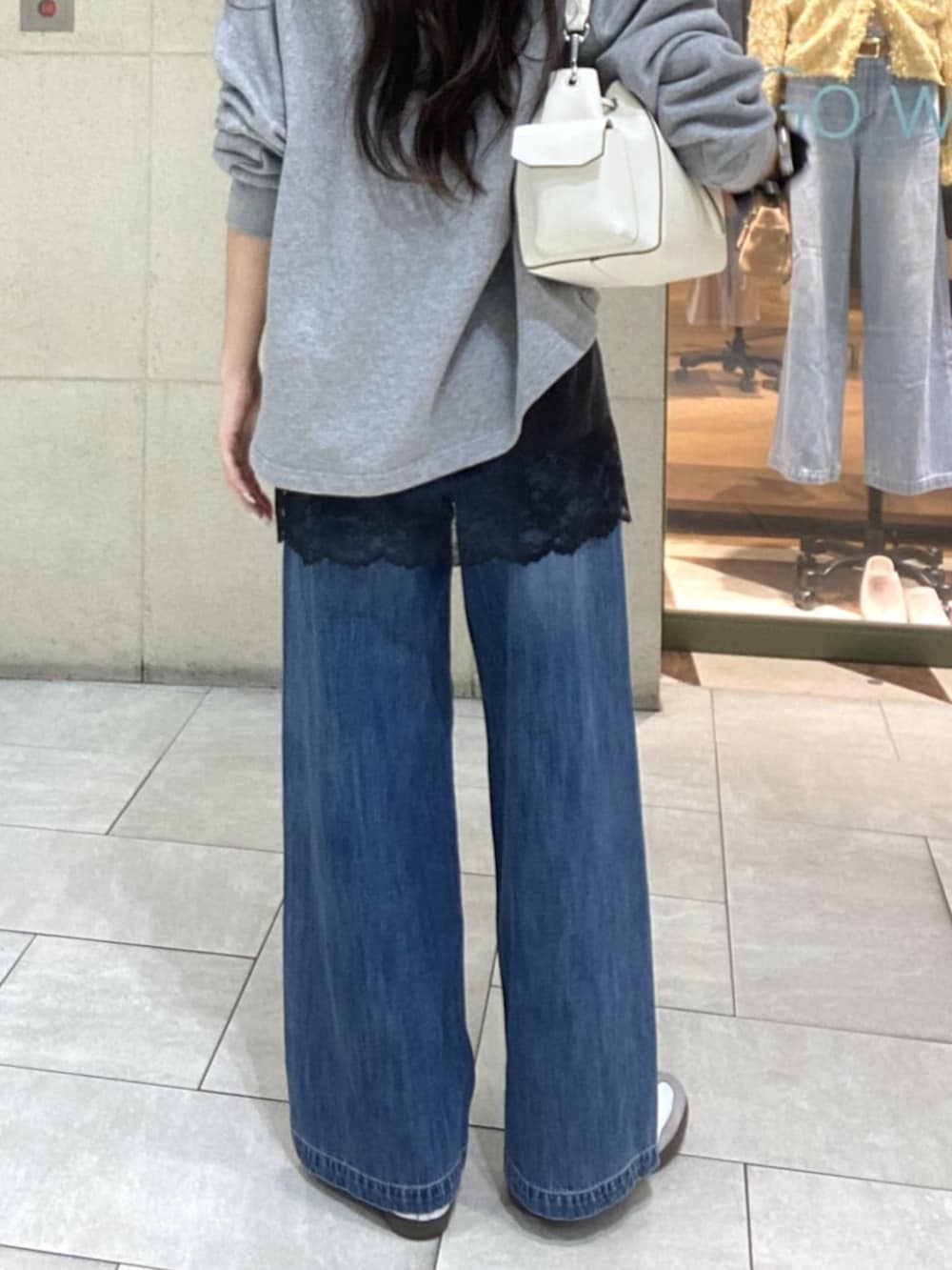 グレー系のスウェット、ブラウン系のキャミソール、ホワイト系のショルダーバッグを着用したレディースの春コーディネートの9枚目の写真