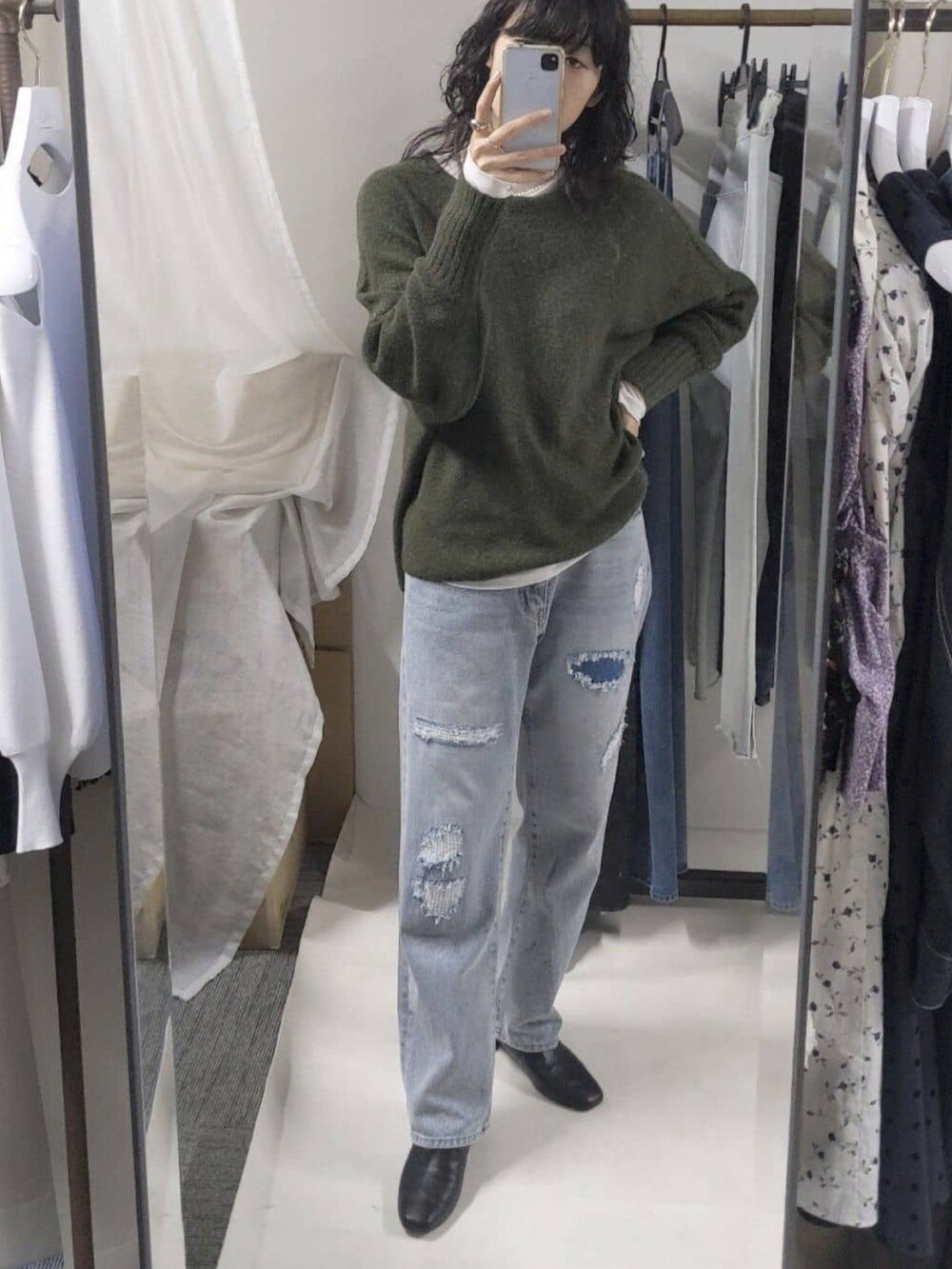 ブルー系のデニムパンツ、ホワイト系のTシャツ/カットソー、ブラック系のブーツを着用したレディースの秋コーディネートの3枚目の写真