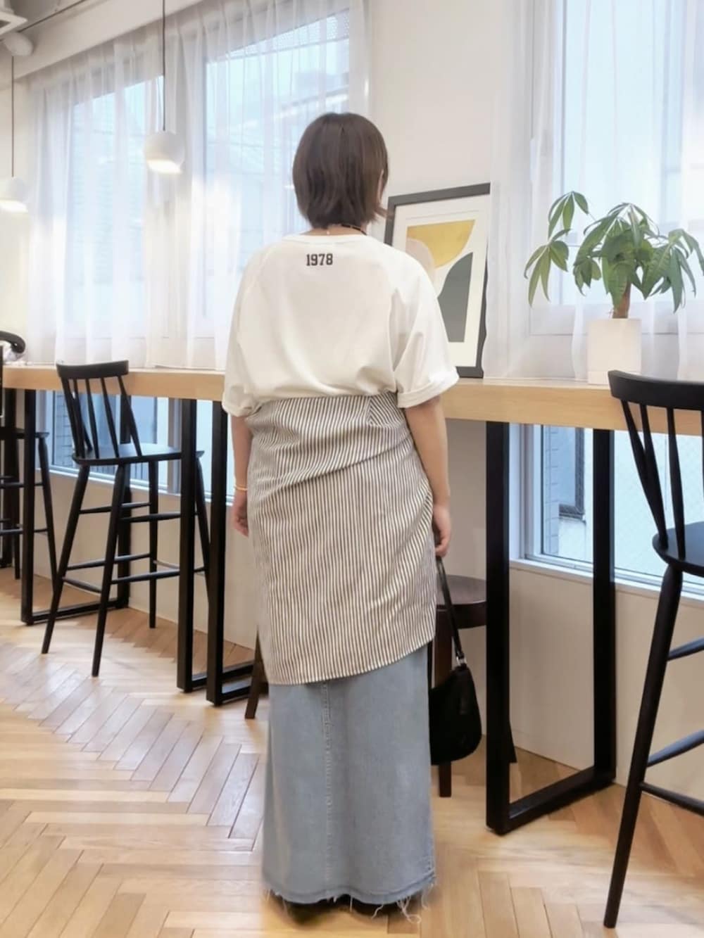 ブラック系のその他シューズ、ホワイト系のTシャツ/カットソー、ブルー系のスカートを着用したレディースの春コーディネートの2枚目の写真