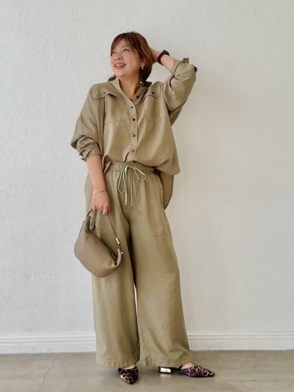 ベージュ系のその他シューズ、グリーン系のシャツ/ブラウス、ベージュ系のショルダーバッグを着用したレディースの春コーディネートの5枚目の写真