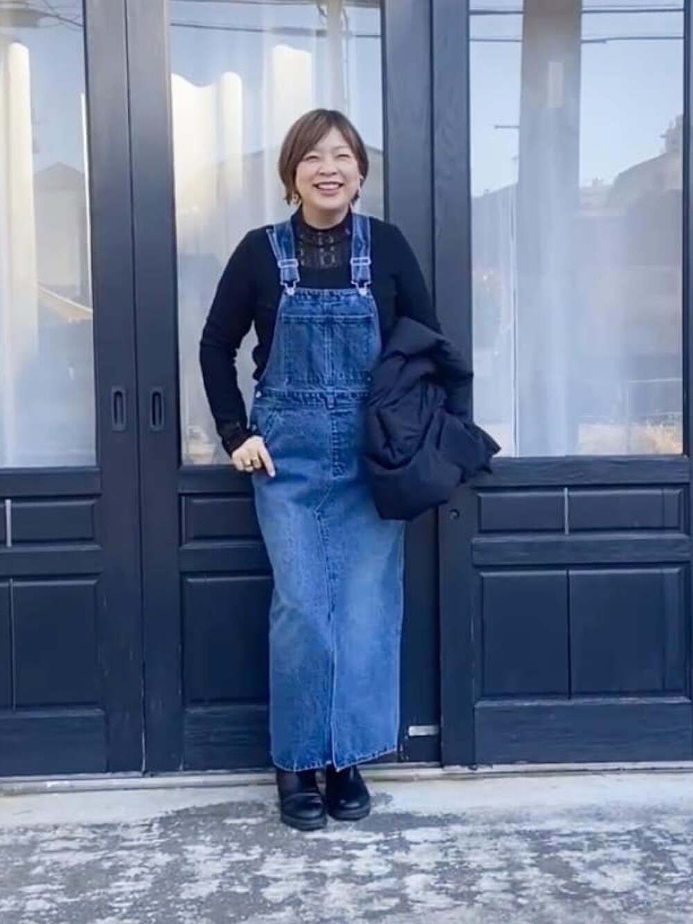 ブラック系のTシャツ/カットソー、ブラック系のダウンジャケット/コート、ブラック系のブーツを着用したレディースの冬コーディネートの2枚目の写真