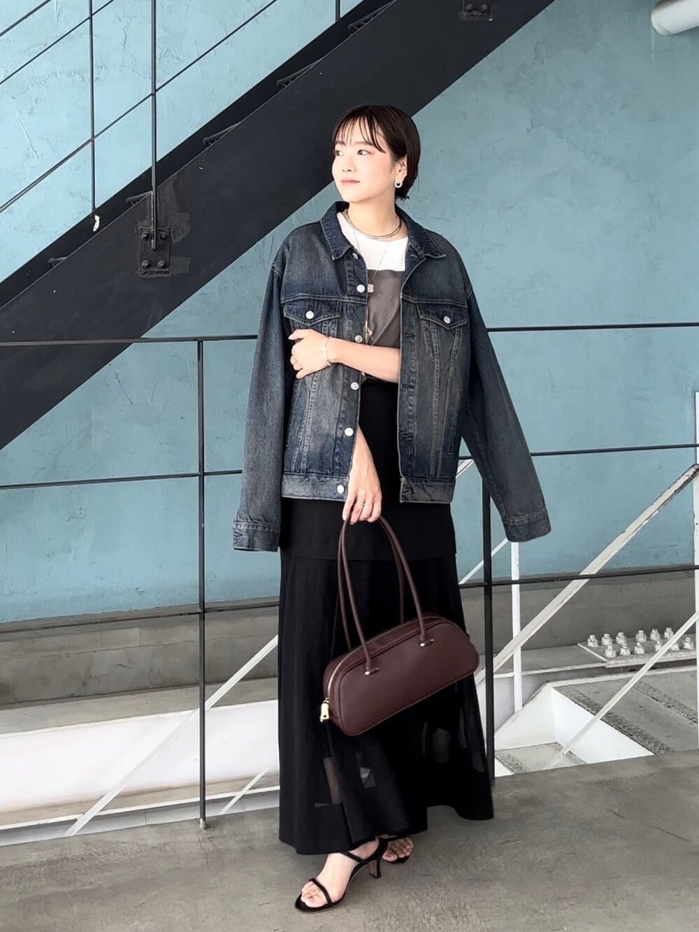 ブラウン系のTシャツ/カットソー、ブルー系のデニムジャケット、ブラック系のスカートを着用したレディースの夏コーディネートの3枚目の写真