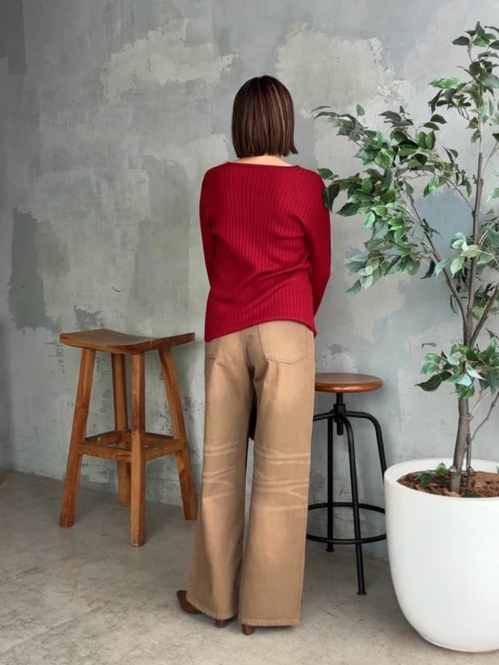 レッド系のカーディガン/ボレロ、ブラウン系のデニムパンツ、ブラウン系のハンドバッグを着用したレディースの夏コーディネートの3枚目の写真