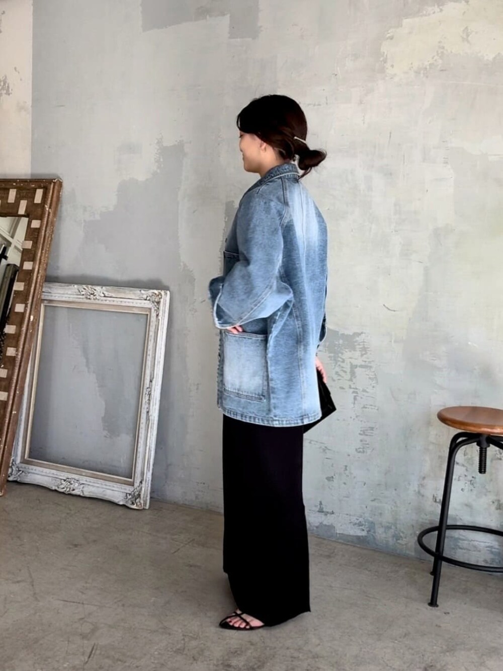 ブルー系のデニムジャケット、ブラック系のワンピース、ブラック系のサンダルを着用したレディースの春コーディネートの2枚目の写真