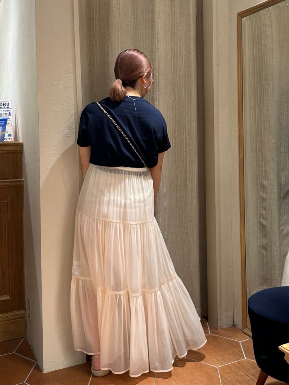 ブルー系のTシャツ/カットソー、ゴールド系のショルダーバッグ、ホワイト系のスカートを着用したレディースの夏コーディネートの2枚目の写真