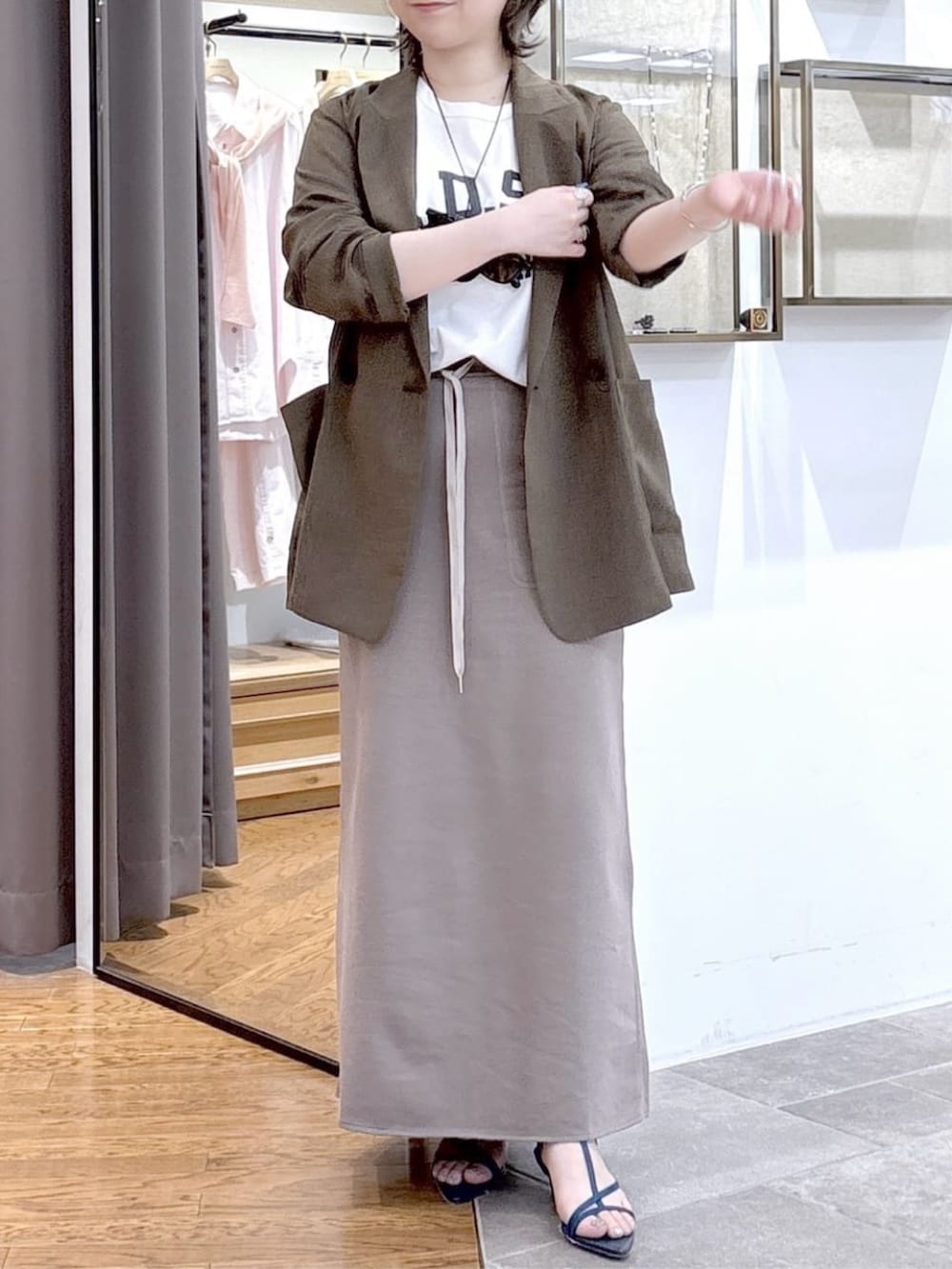 ホワイト系のTシャツ/カットソー、ブラウン系のテーラードジャケット、ブルー系のサンダルを着用したレディースの春コーディネートの4枚目の写真