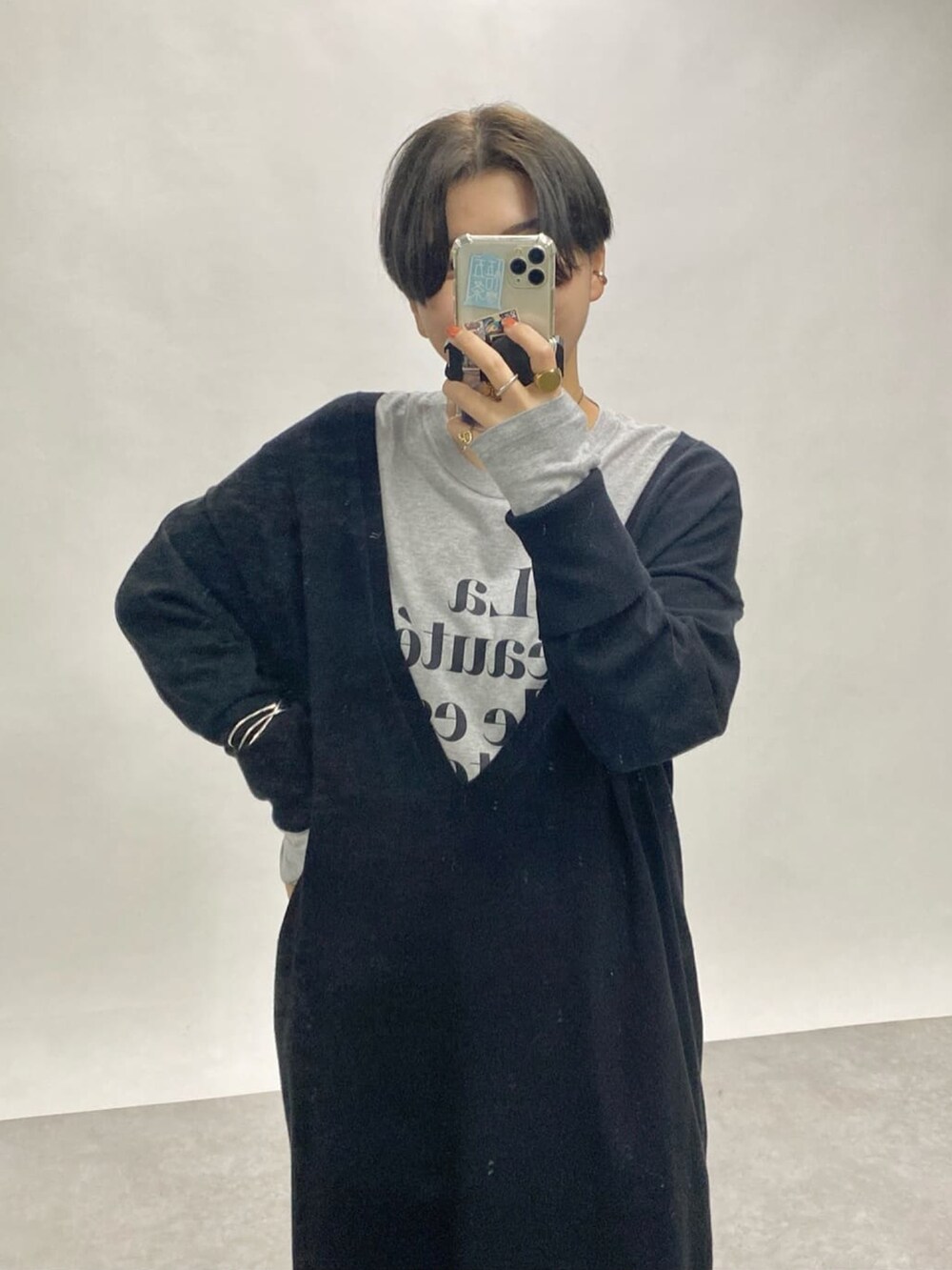 グレー系のTシャツ/カットソー、ブラック系のワンピースを着用したレディースの秋コーディネートの2枚目の写真