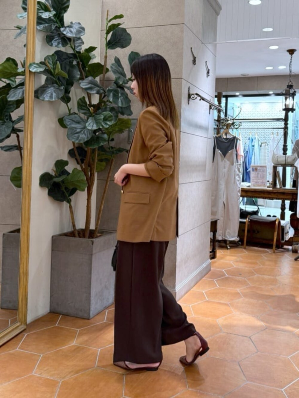 ベージュ系のTシャツ/カットソー、ブラック系のボストンバッグ、ブラウン系のテーラードジャケットを着用したレディースの夏コーディネートの3枚目の写真