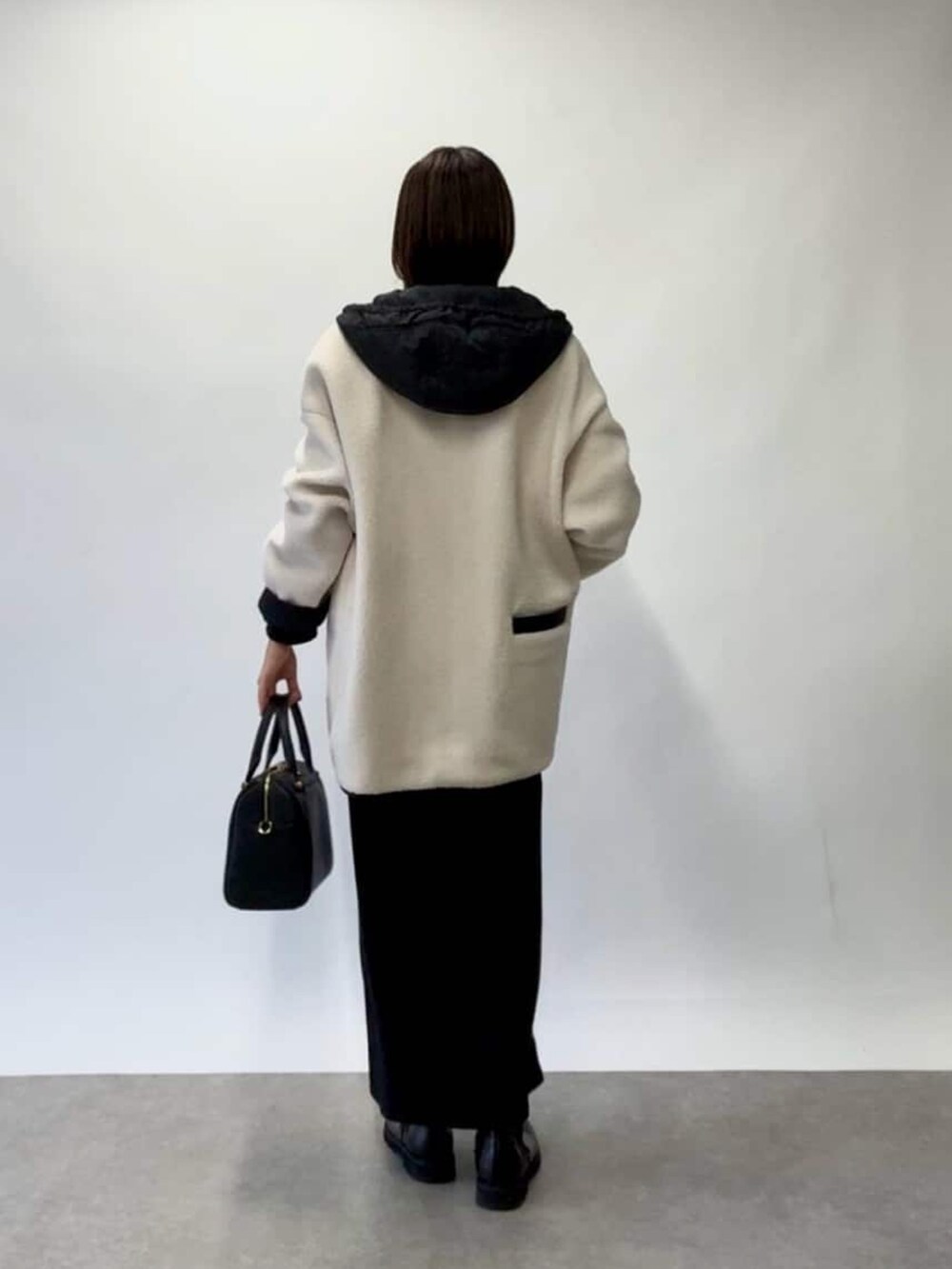 ホワイト系のその他アウター、グレー系のニット/セーター、ブラック系のワンピースを着用したレディースの秋コーディネートの3枚目の写真