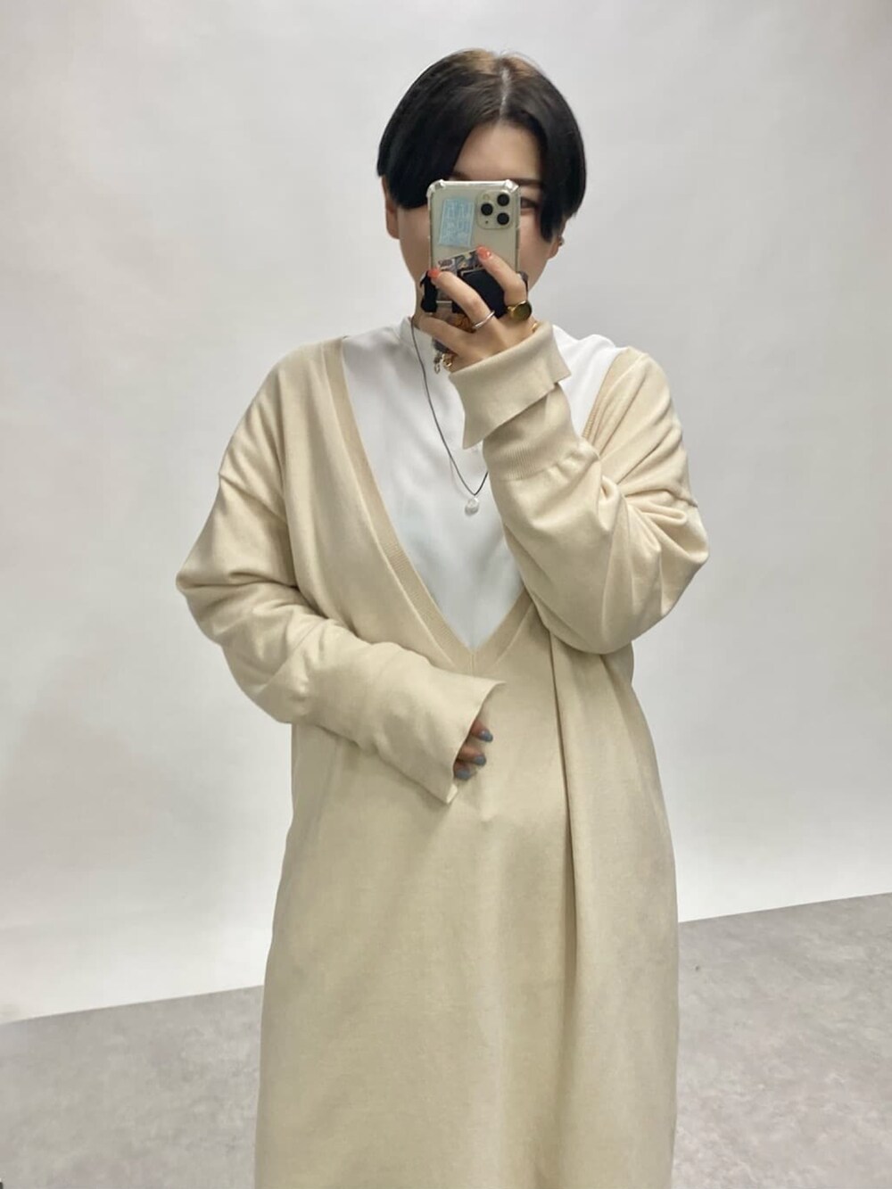 ホワイト系のTシャツ/カットソー、ブルー系のデニムパンツ、ホワイト系のワンピースを着用したレディースの秋コーディネートの2枚目の写真