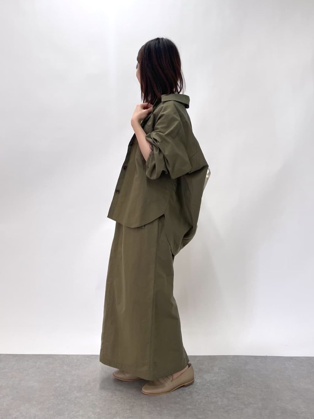 ホワイト系のニット/セーター、グリーン系のシャツ/ブラウス、グリーン系のスカートを着用したレディースの春コーディネートの3枚目の写真