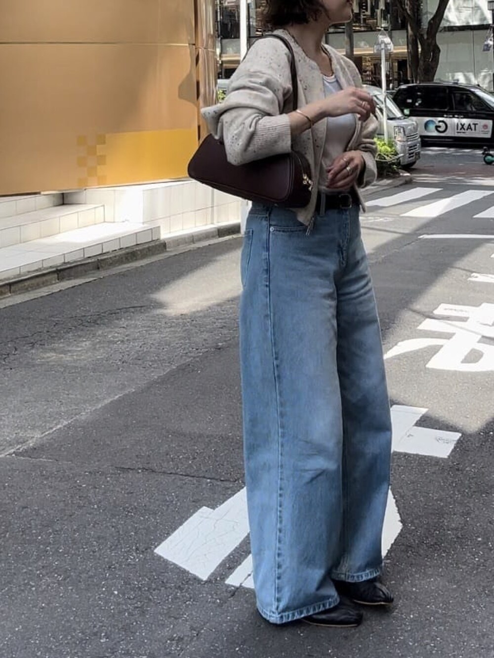 ブルー系のデニムパンツ、ホワイト系のニット/セーター、ブラック系のパンプスを着用したレディースの秋コーディネートの3枚目の写真