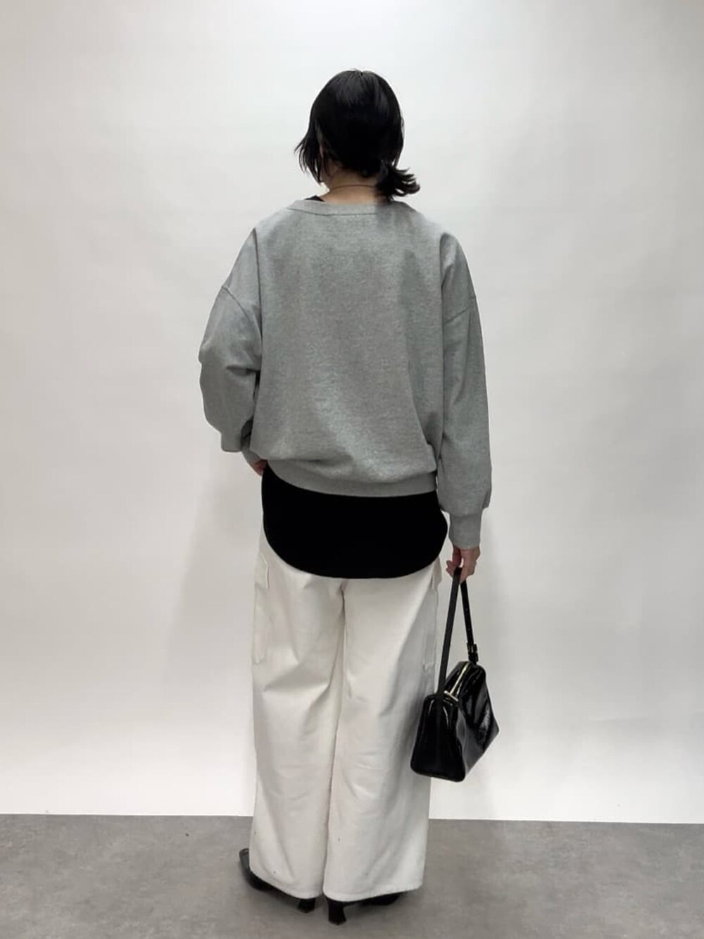 ホワイト系のカーゴパンツ、ブラック系のショルダーバッグ、ブラック系のローファーを着用したレディースの冬コーディネートの3枚目の写真