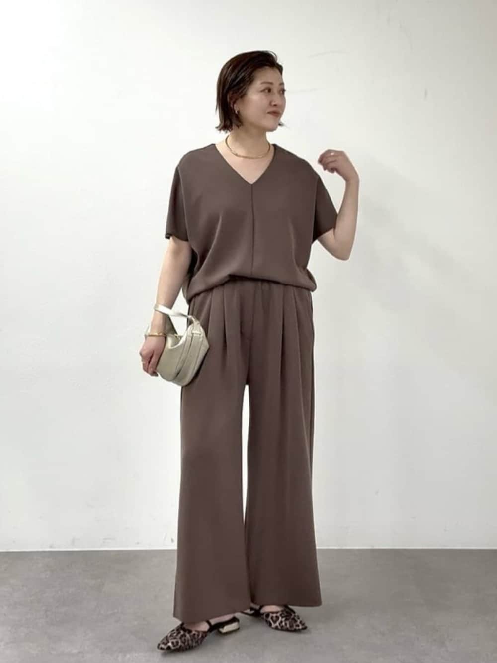 ベージュ系のその他シューズ、ゴールド系のショルダーバッグ、ブラウン系のその他パンツを着用したレディースの春コーディネートの4枚目の写真