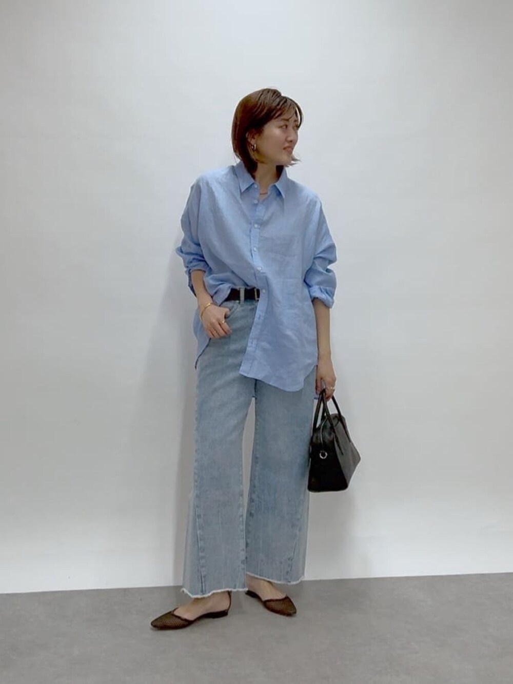 ブルー系のデニムパンツ、ブルー系のシャツ/ブラウス、ブラック系のパンプスを着用したレディースの冬コーディネートの3枚目の写真