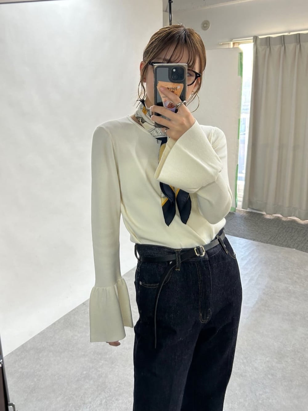 ブラック系のその他アウター、ホワイト系のニット/セーター、ブルー系のデニムパンツを着用したレディースの冬コーディネートの5枚目の写真