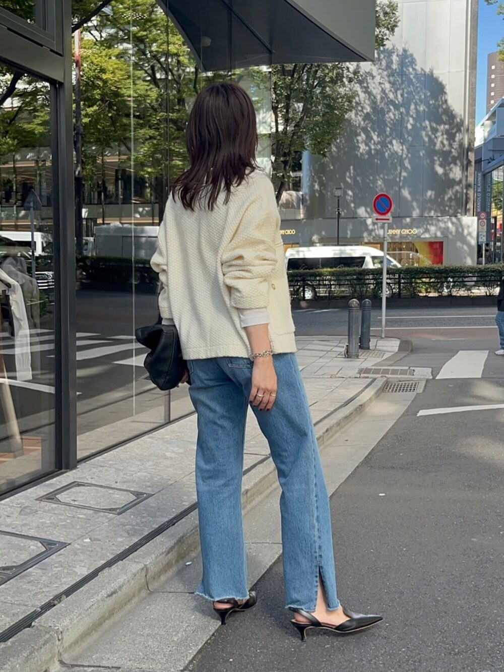 ブルー系のデニムパンツ、ホワイト系のTシャツ/カットソー、ホワイト系のカーディガン/ボレロを着用したレディースの秋コーディネートの3枚目の写真