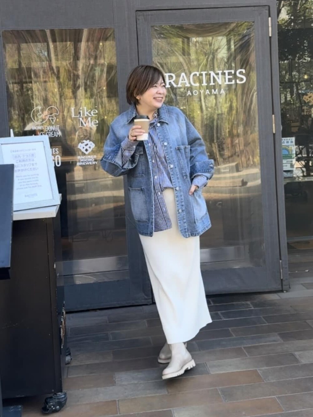 ブルー系のデニムジャケット、ホワイト系のスカート、ブラック系のシャツ/ブラウスを着用したレディースの冬コーディネートの2枚目の写真