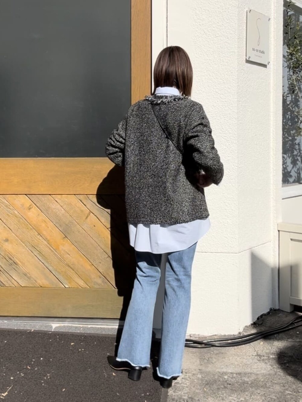 ブラウン系のカーディガン/ボレロ、ブルー系のデニムパンツ、グリーン系のショルダーバッグを着用したレディースの冬コーディネートの5枚目の写真