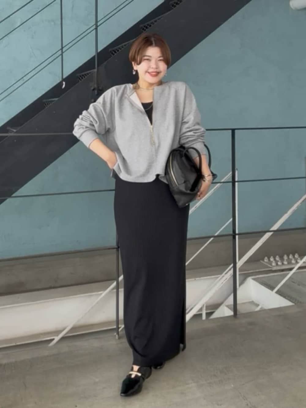 グレー系のスウェット、ブラック系のワンピース、シルバー系のチョーカーを着用したレディースの春コーディネートの2枚目の写真