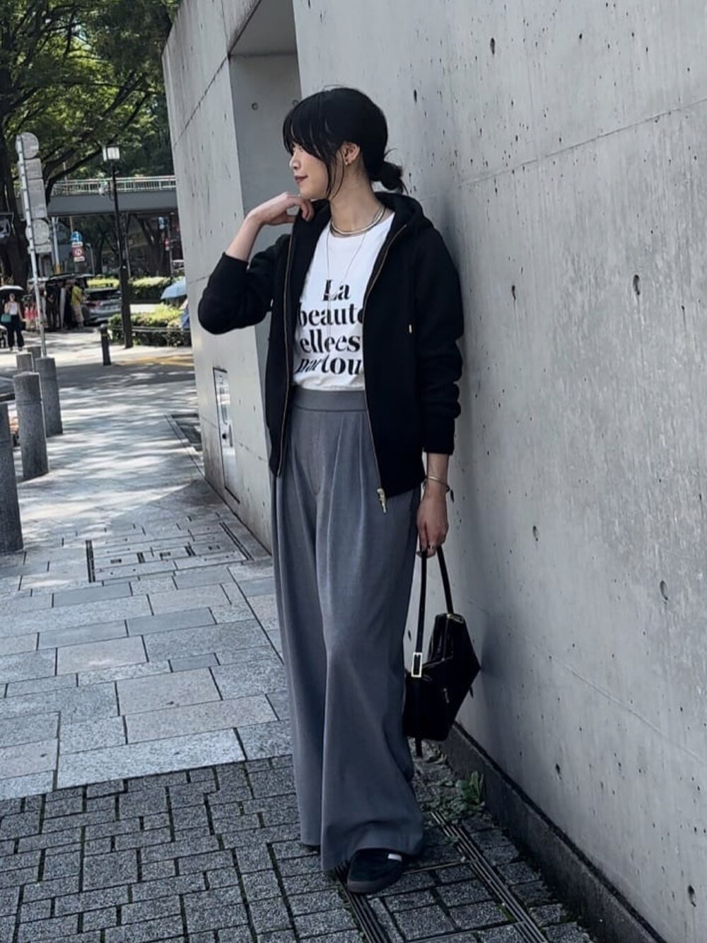 ブラック系のパーカー、グレー系のスラックス、ホワイト系のTシャツ/カットソーを着用したレディースの秋コーディネートの3枚目の写真