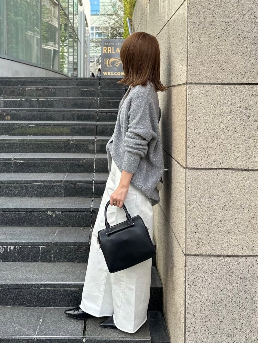 グレー系のカーディガン/ボレロ、ホワイト系のデニムパンツ、ブラック系のボストンバッグを着用したレディースの秋コーディネートの2枚目の写真