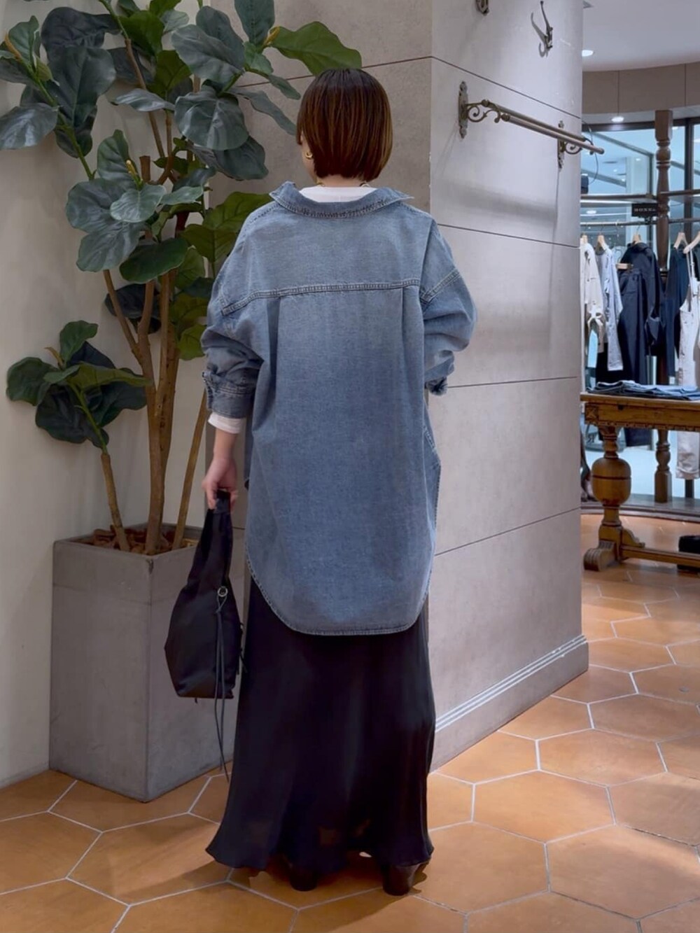 ブルー系のシャツ/ブラウス、ブラック系のスカート、グリーン系のハンドバッグを着用したレディースの冬コーディネートの3枚目の写真