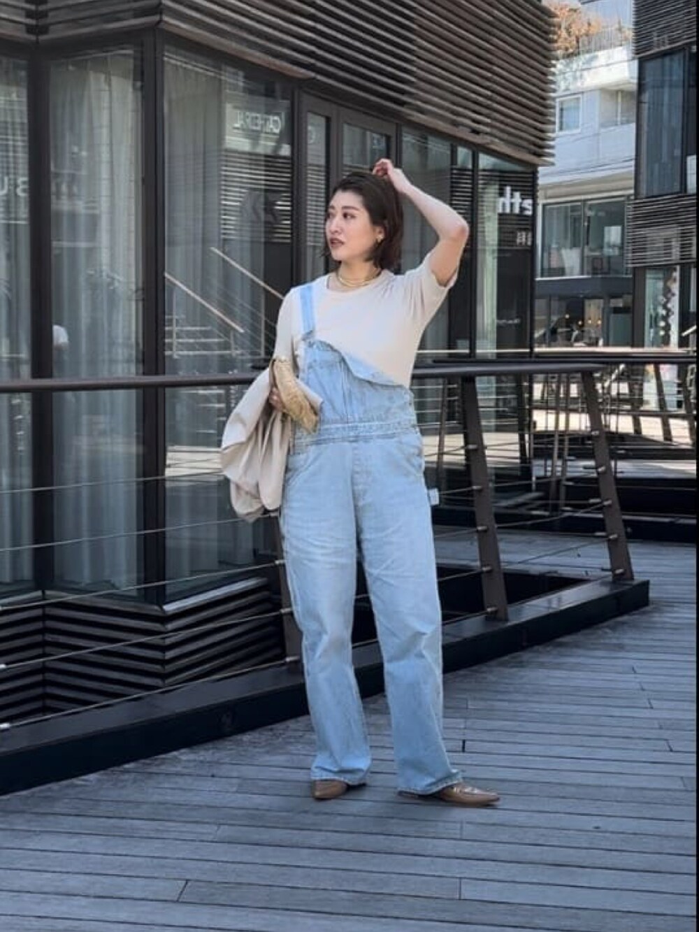 ブルー系のサロペット/オーバーオール、グレー系のTシャツ/カットソーを着用したレディースの春コーディネートの2枚目の写真