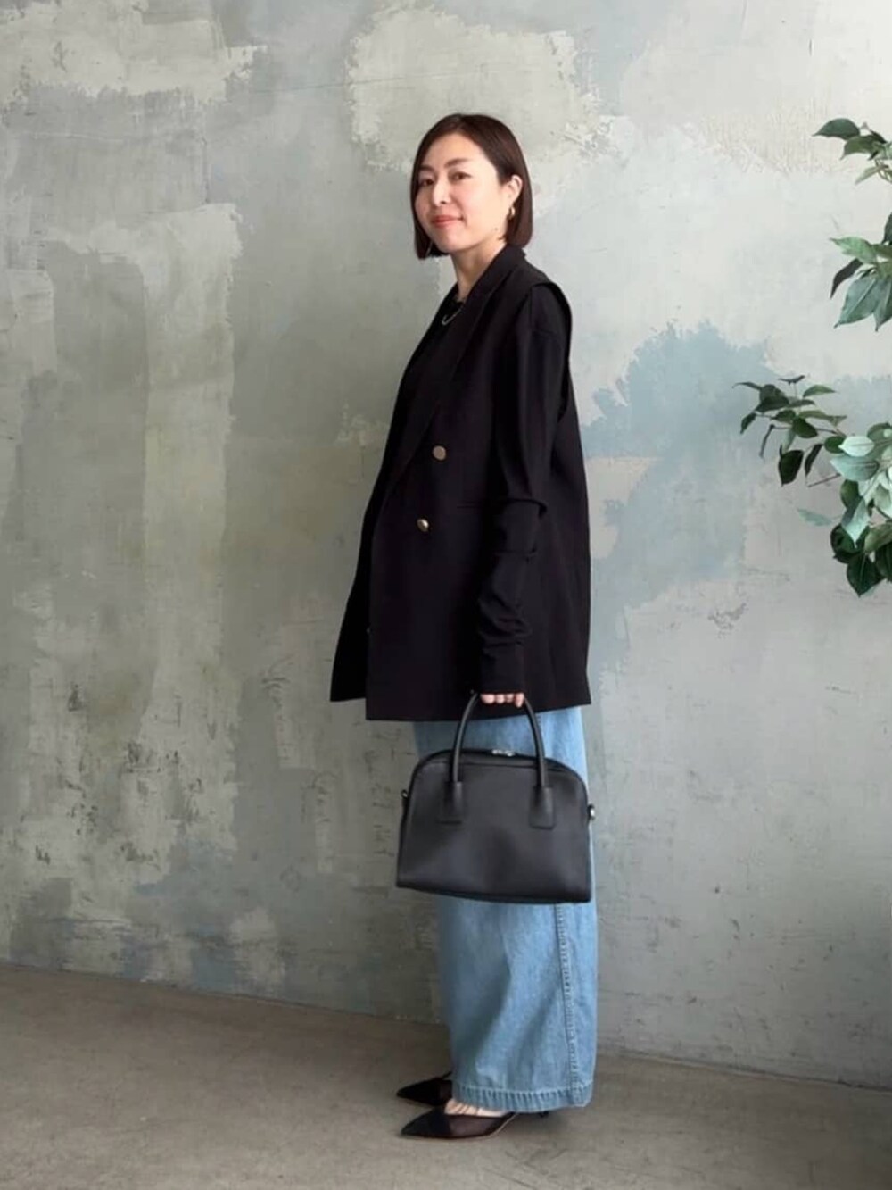 ブラック系のTシャツ/カットソー、ブラック系のベスト、ブルー系のシャツワンピースを着用したレディースの冬コーディネートの2枚目の写真