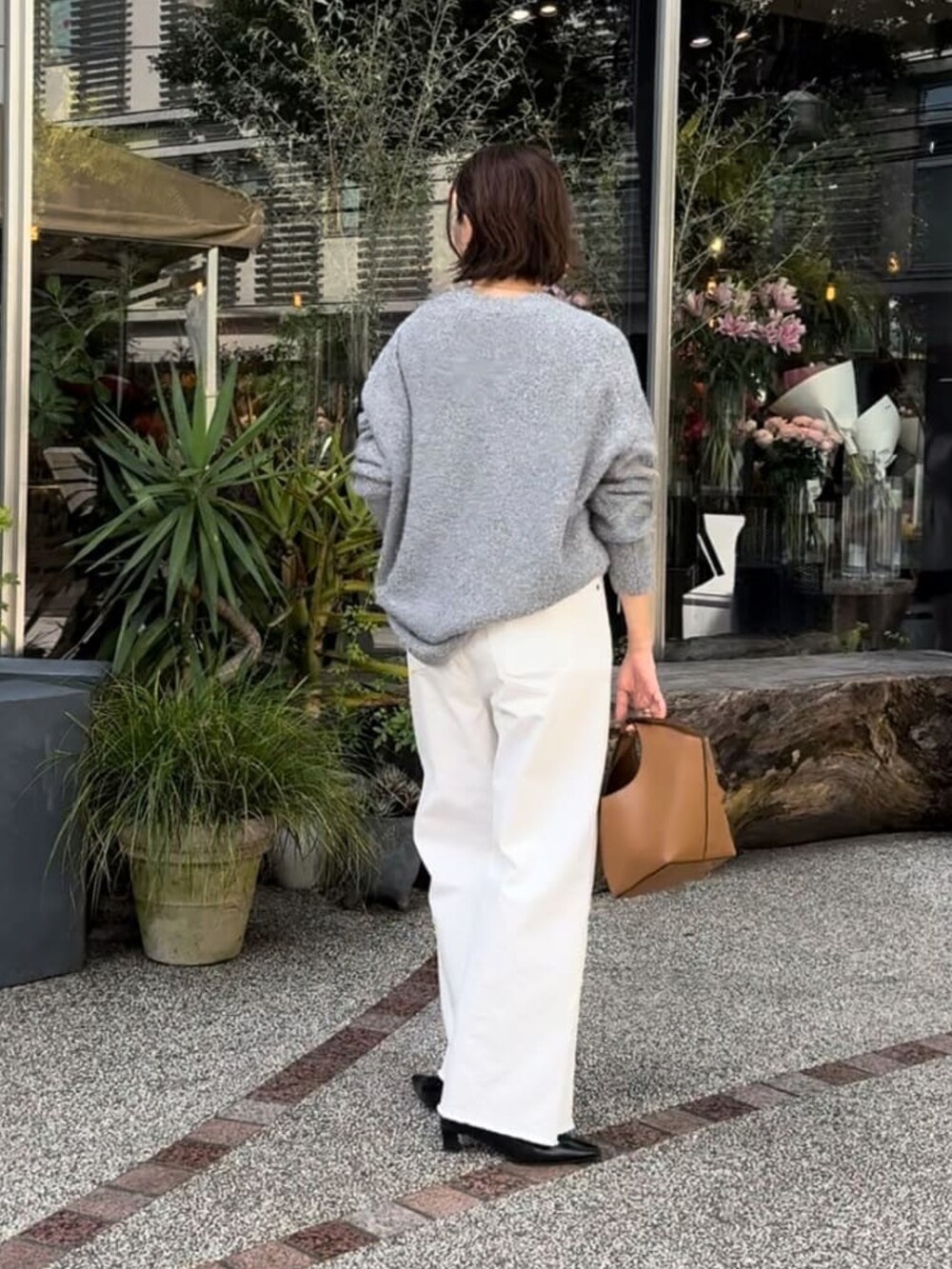 グレー系のカーディガン/ボレロ、ホワイト系のデニムパンツ、イエロー系のハンドバッグを着用したレディースの秋コーディネートの3枚目の写真