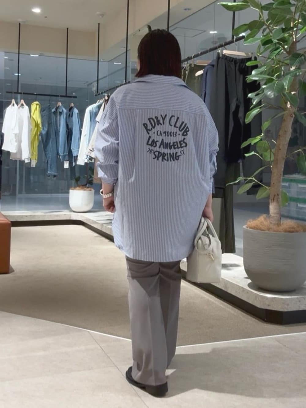 ホワイト系のボストンバッグ、ブルー系のシャツ/ブラウス、ブラック系のキャミソールを着用したレディースの春コーディネートの3枚目の写真