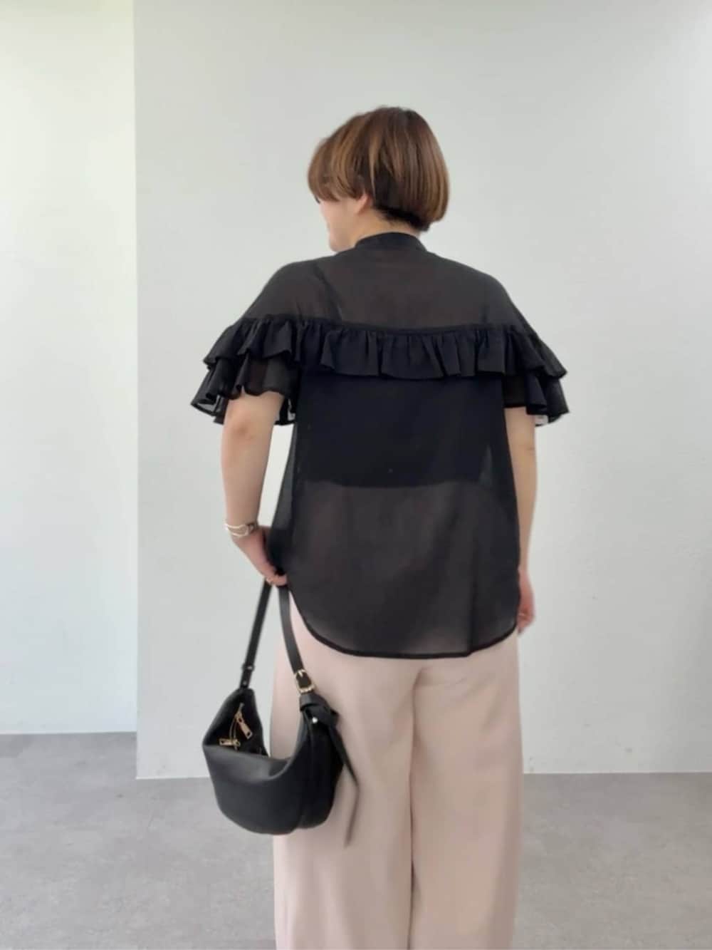 ピンク系のスラックス、ブラック系のショルダーバッグ、ブラック系のシャツ/ブラウスを着用したレディースの夏コーディネートの6枚目の写真