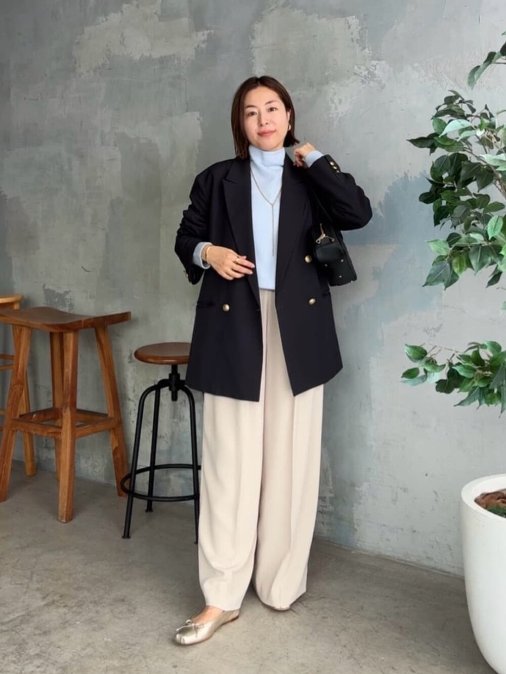 ブルー系のニット/セーター、ブルー系のテーラードジャケット、ベージュ系のその他パンツを着用したレディースの秋コーディネートの2枚目の写真