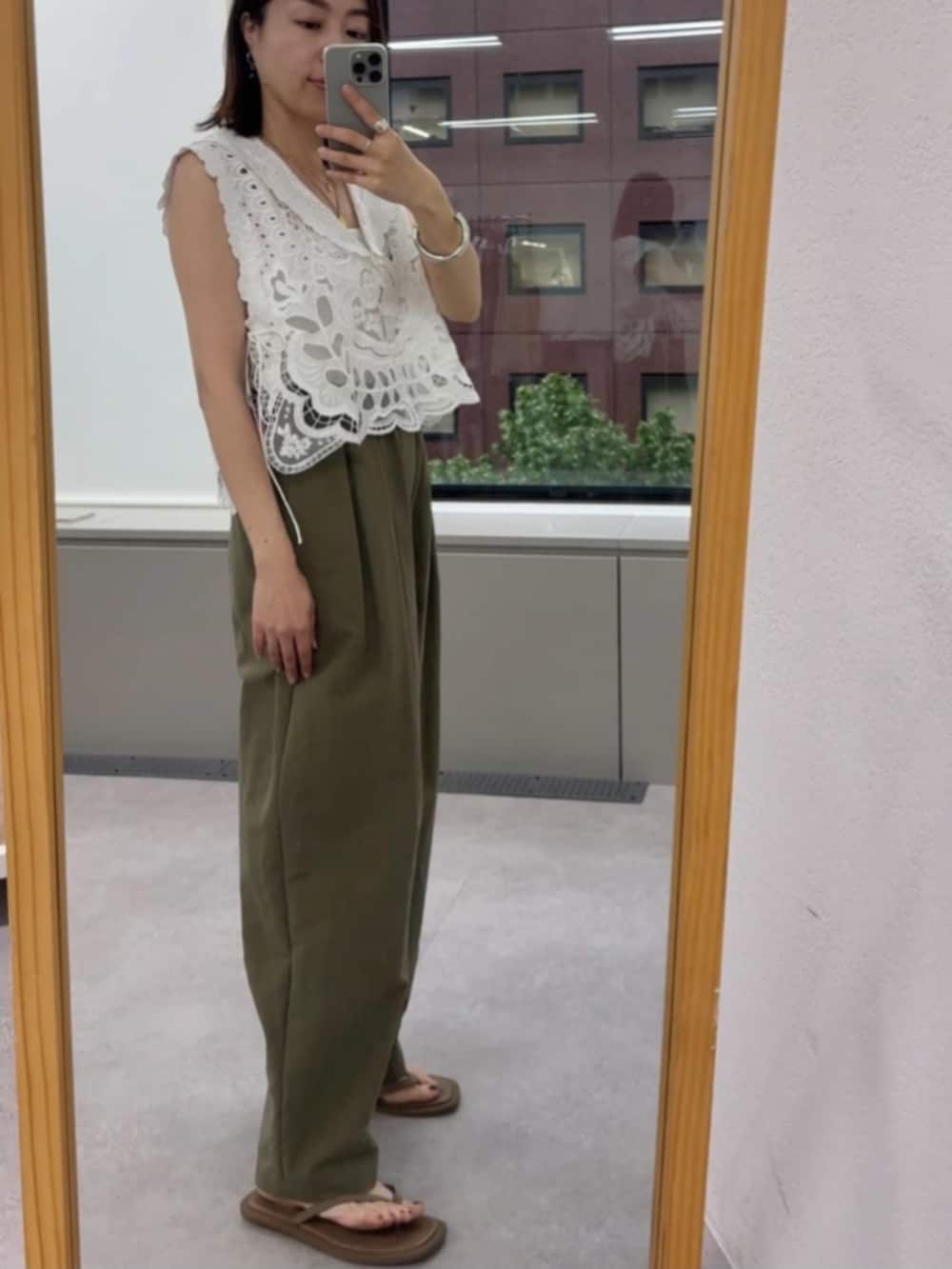 グリーン系のその他パンツ、ホワイト系のベスト、ベージュ系のサンダルを着用したレディースの夏コーディネートの2枚目の写真