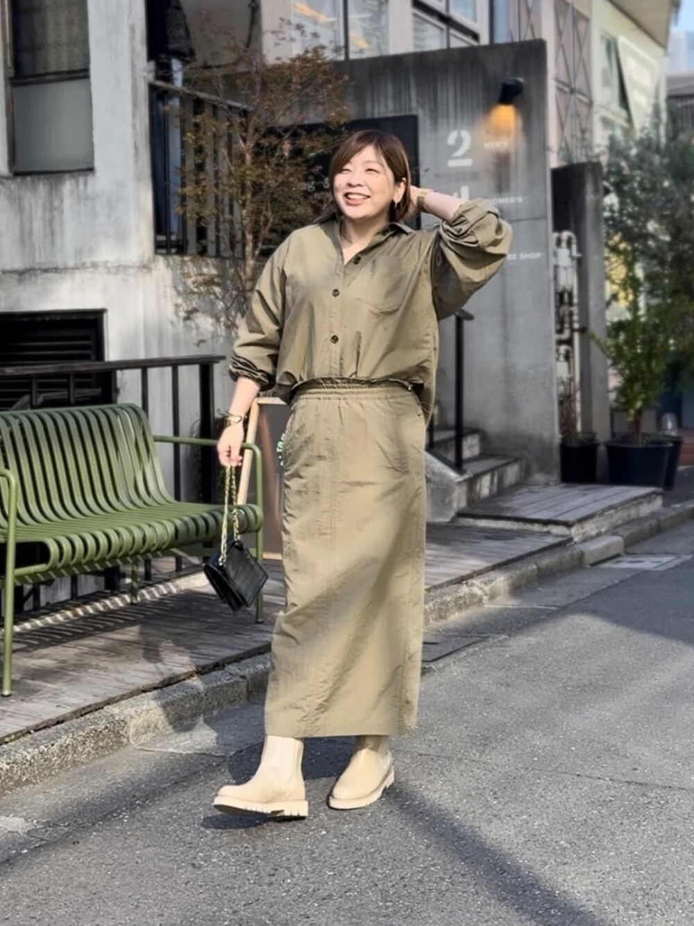 ベージュ系のシャツ/ブラウス、ベージュ系のスカート、ブラック系のショルダーバッグを着用したレディースの冬コーディネートの3枚目の写真