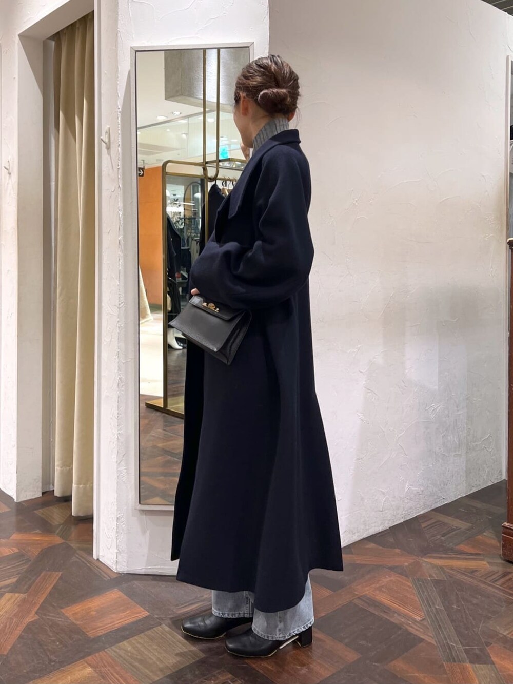 ブラック系のハンドバッグ、ブルー系のその他アウター、グレー系のニット/セーターを着用したレディースの冬コーディネートの3枚目の写真