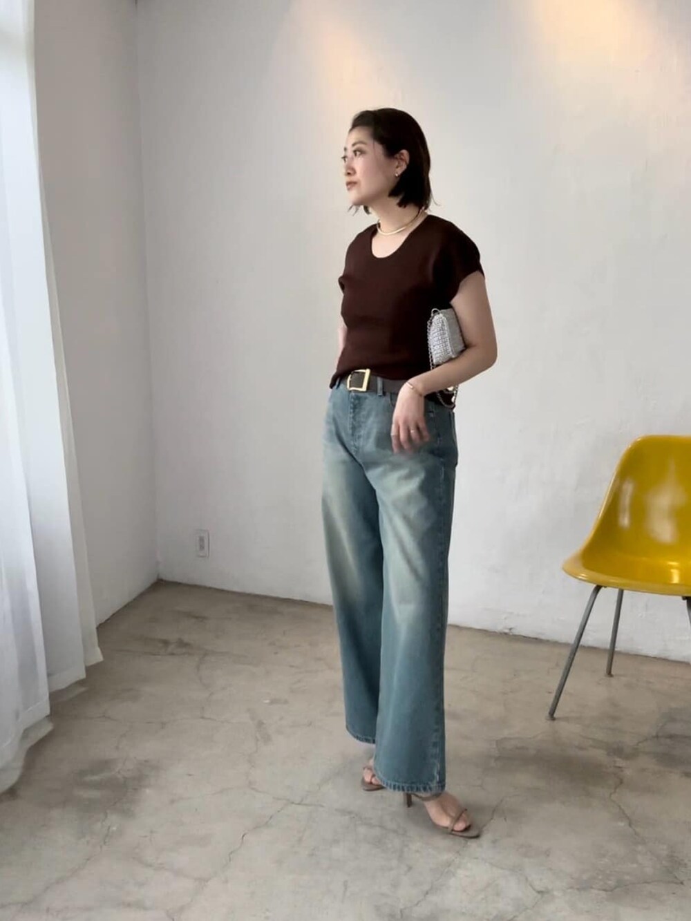 ホワイト系のニット/セーター、ブルー系のデニムパンツ、グレー系のサンダルを着用したレディースの春コーディネートの2枚目の写真