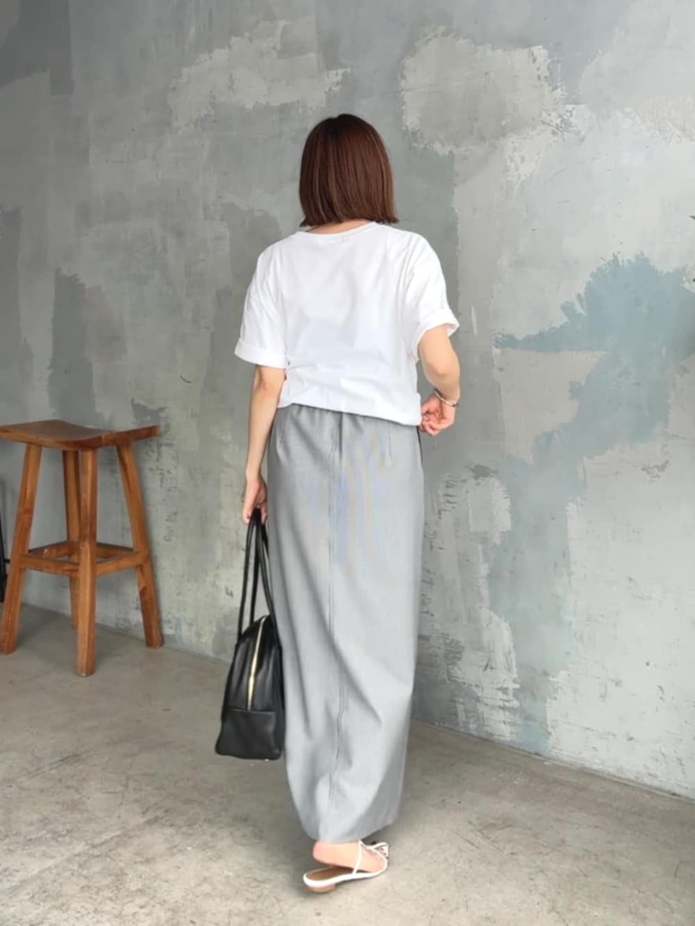 ホワイト系のTシャツ/カットソー、ホワイト系のサンダル、ブラック系のスカートを着用したレディースの夏コーディネートの3枚目の写真