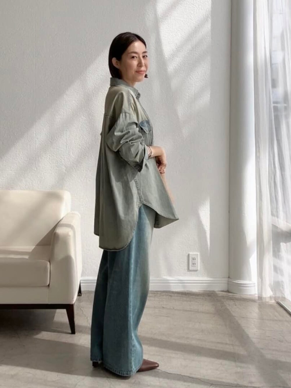 ブラック系のキャミソール、ブルー系のシャツ/ブラウス、ブルー系のデニムパンツを着用したレディースの夏コーディネートの2枚目の写真